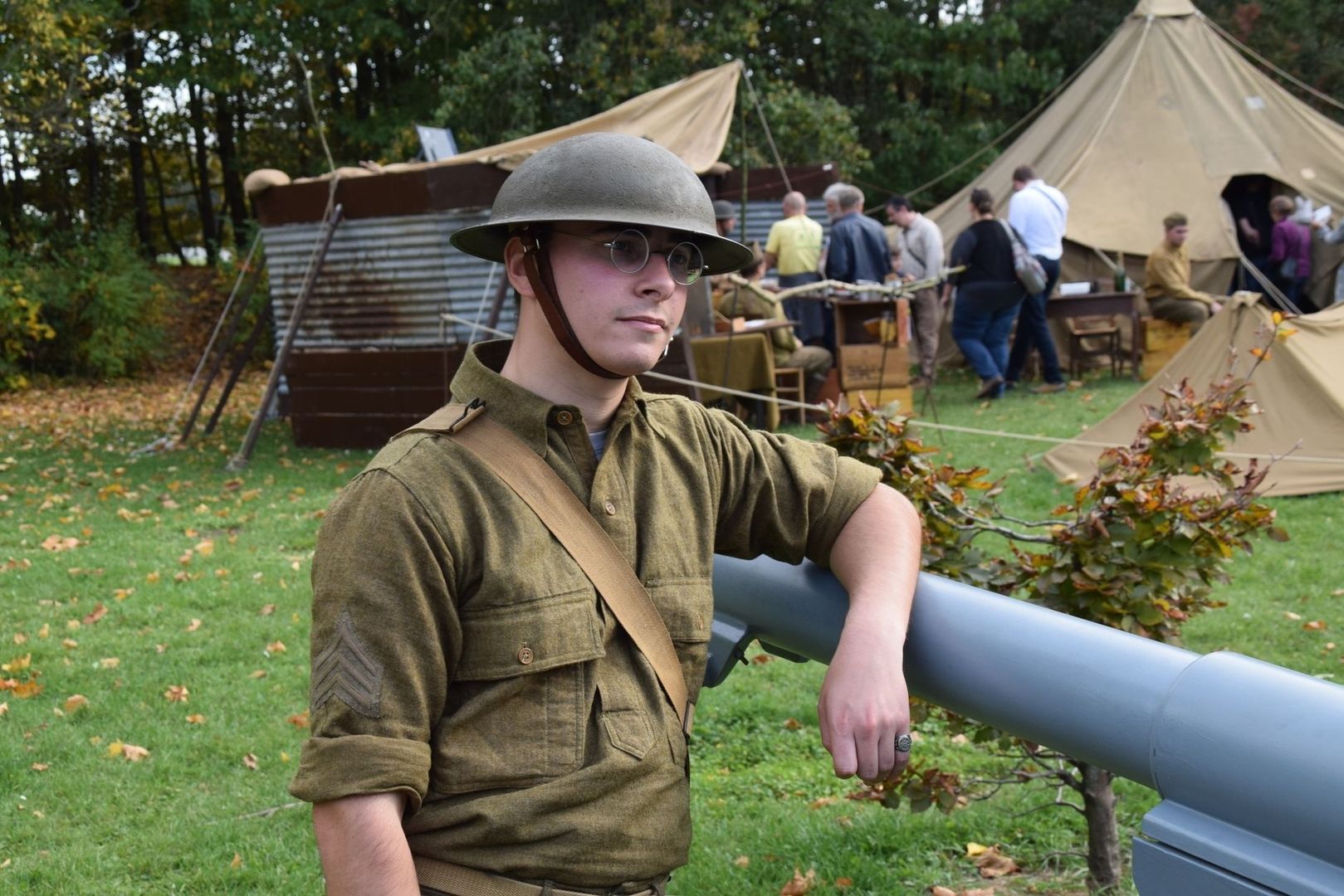 Man in historisch militair uniform bij tenten en een groot kanon