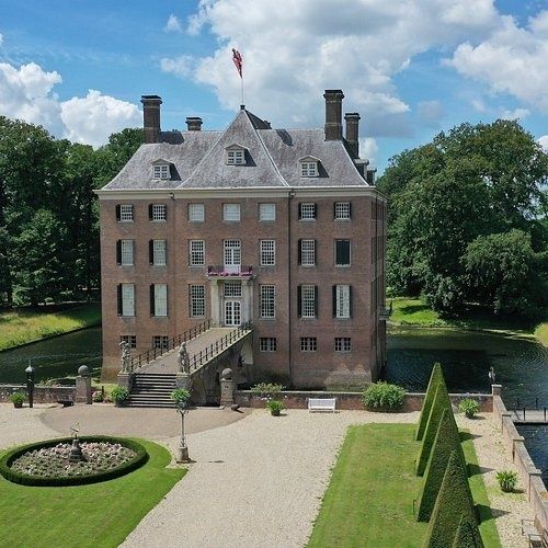 Kasteel Amerongen met slotgracht, tuin en Nederlandse vlag